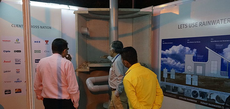 An exhibitor explains his product to conference participants