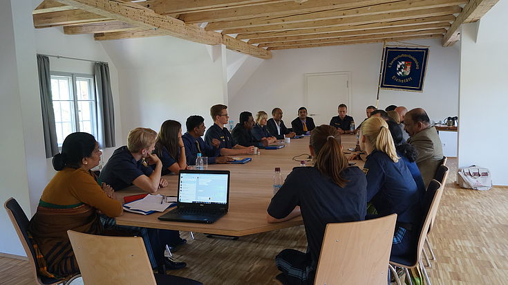 The Indian delegation and Bavarian police trainees discuss commonalities and differences in their police education system